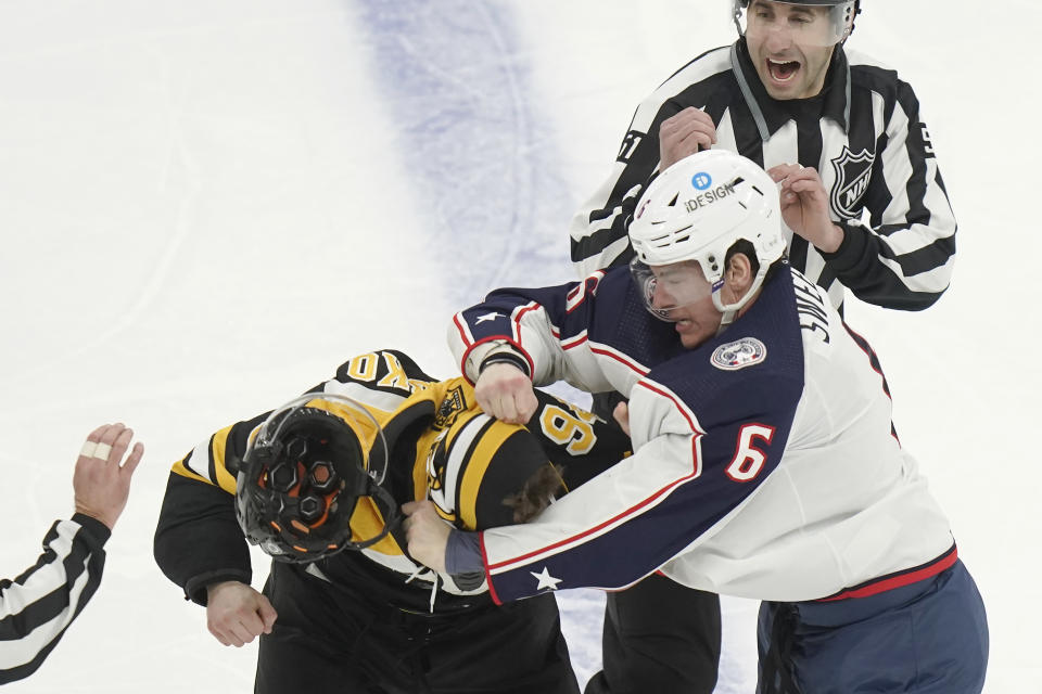 Boston Bruins center Jakub Lauko, left, and Columbus Blue Jackets defenseman Billy Sweezey, right, exchange blows in the second period of an NHL hockey game, Thursday, March 30, 2023, in Boston. (AP Photo/Steven Senne)