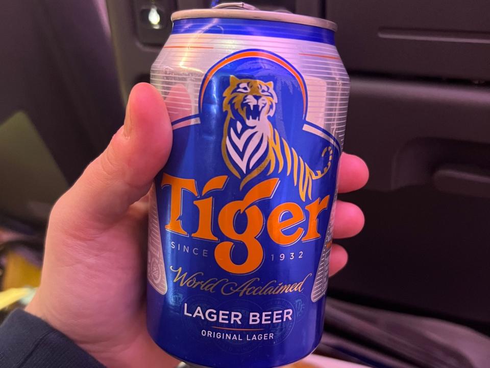 Me holding Tiger beer, which has a tiger and says "Tiger" in orange lettering.