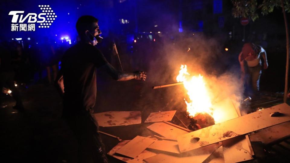 圖／達志影像美聯社，部分抗議民眾在內政部長官邸外焚燒木板。