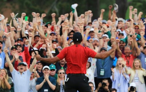 Spectators roar with delight as Tiger Woods celebrates on the 18th green after winning the 2019 Masters for his 15th career major triumph