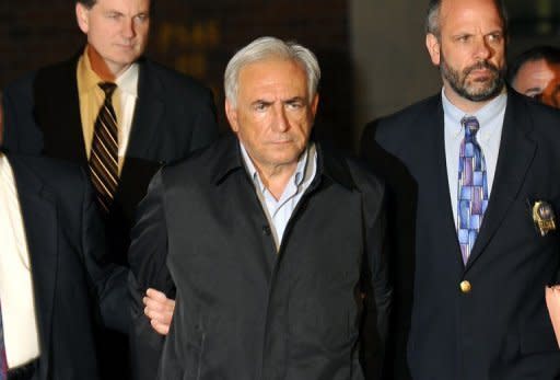 IMF head Dominique Strauss-Kahn (C) is taken out of a police station in New York on May 15, 2011. Strauss-Kahn was charged Sunday with attempting to rape a New York chambermaid, unleashing a scandal which could bury his long-held ambitions to be elected the president of France