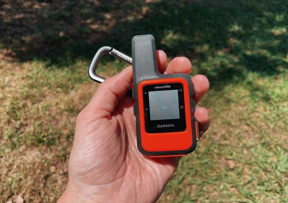 closeup view of  Garmin inReach Mini device and grass in the background