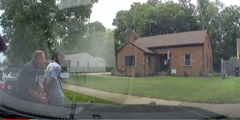 This Aug. 1, 2021 image from video provided by the Wyoming, Mich., Police Department shows a Wyoming Officer handcuffing real estate agent Eric Brown outside a home he was showing to a potential buyer in Wyoming, Mich. Police handcuffed the realtor, his client and that man’s 15-year-old son this month after a neighbor wrongly reported the three Black people were breaking into a home. 