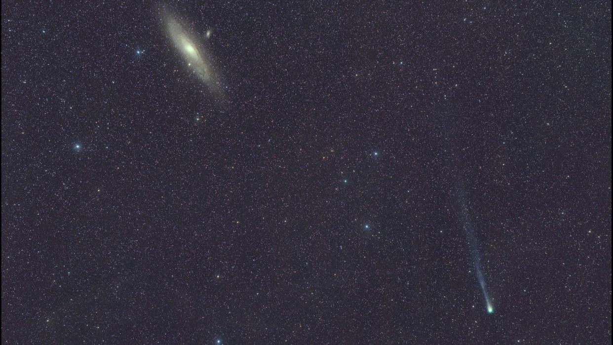  A bright, fuzzy dot can be seen among a background of stars, leaving a wispy trail behind it. 