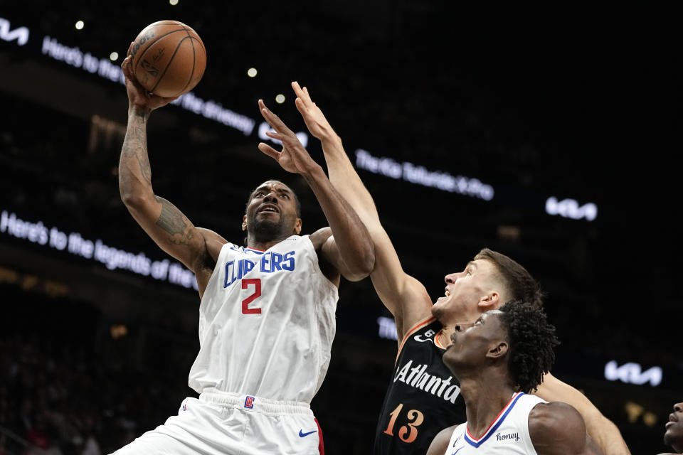 Los Angeles Clippers forward Kawhi Leonard (2) scores as Atlanta Hawks guard Bogdan Bogdanovic (13) defends during the first half of an NBA basketball game Saturday, Jan. 28, 2023, in Atlanta. (AP Photo/John Bazemore)