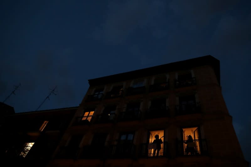 Spanish blues singer "Betta" sings from her balcony next to guitar player Capalbo during a daily evening concert to support health workers and to make it easier for her neighbours to bear the coronavirus lockdown in Madrid