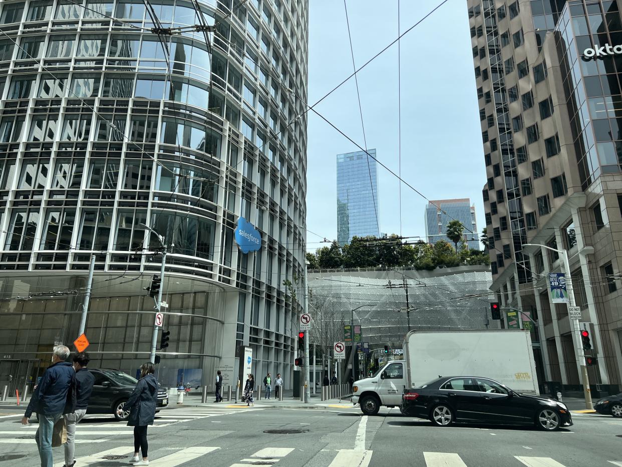 Pedestrians and vehicles are visible at the base of the Salesforce Tower in San Francisco.