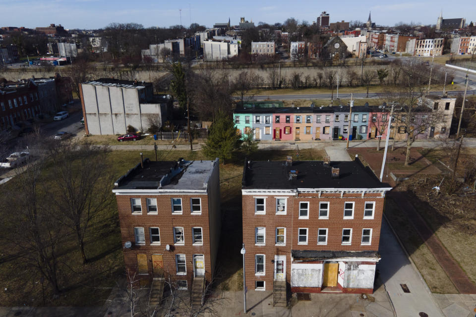 Vacant homes, including one, bottom left, once rented by Angela Banks are visible with boarded doors and windows, Wednesday, Feb. 15, 2023, in Baltimore. In 2018, Banks was told by her landlord that Baltimore officials were buying her family's home of four decades, planning to demolish the three-story brick rowhouse to make room for an urban renewal project aimed at transforming their historically Black neighborhood. Banks and her children became homeless almost overnight. Banks filed a complaint Monday asking federal officials to investigate whether Baltimore's redevelopment policies are perpetuating racial segregation and violating fair housing laws by disproportionately displacing Black and low-income residents. (AP Photo/Julio Cortez)