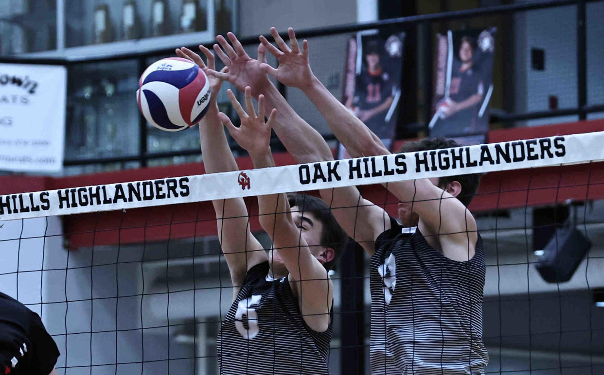 Lakota East players Grant Simer (12) and Matteo Puddu (5) block a kill attempt during their volleyball game against Oak Hills Thursday, April 4.