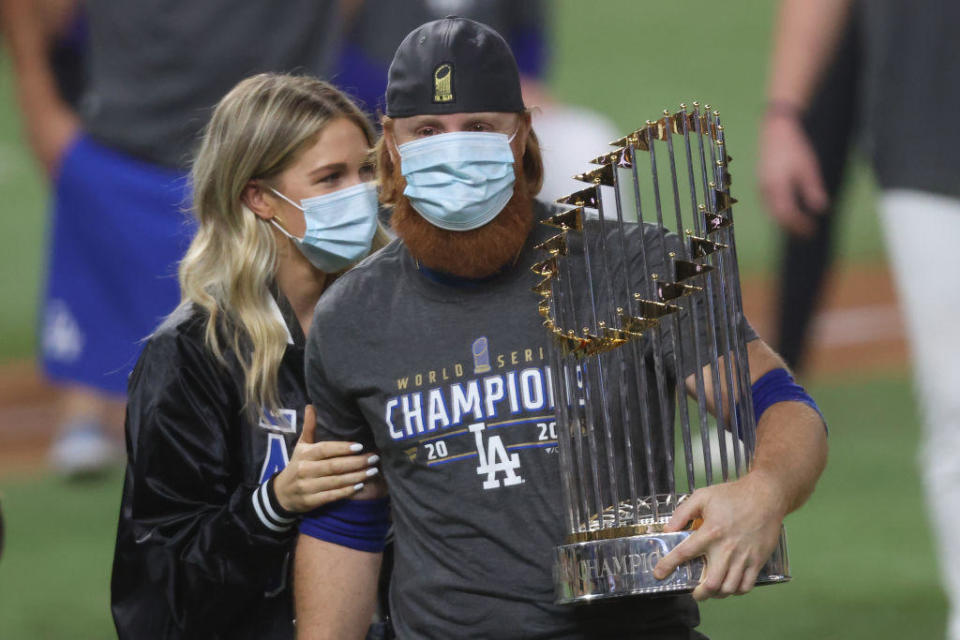 Justin Turner of the Los Angeles Dodgers and his wife, Kourtney Pogue, hold the Commissioners Trophy on October 27, 2020, in Arlington, Texas. / Credit: Tom Pennington/Getty