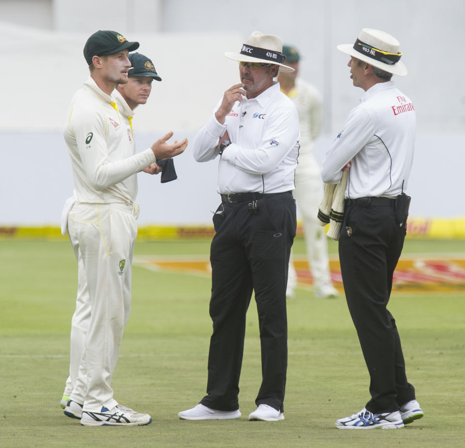 Umpires Nigel Llong and Richard Illingworth confront Cameron Bancroft (pictured left) over a piece of sadpaper.