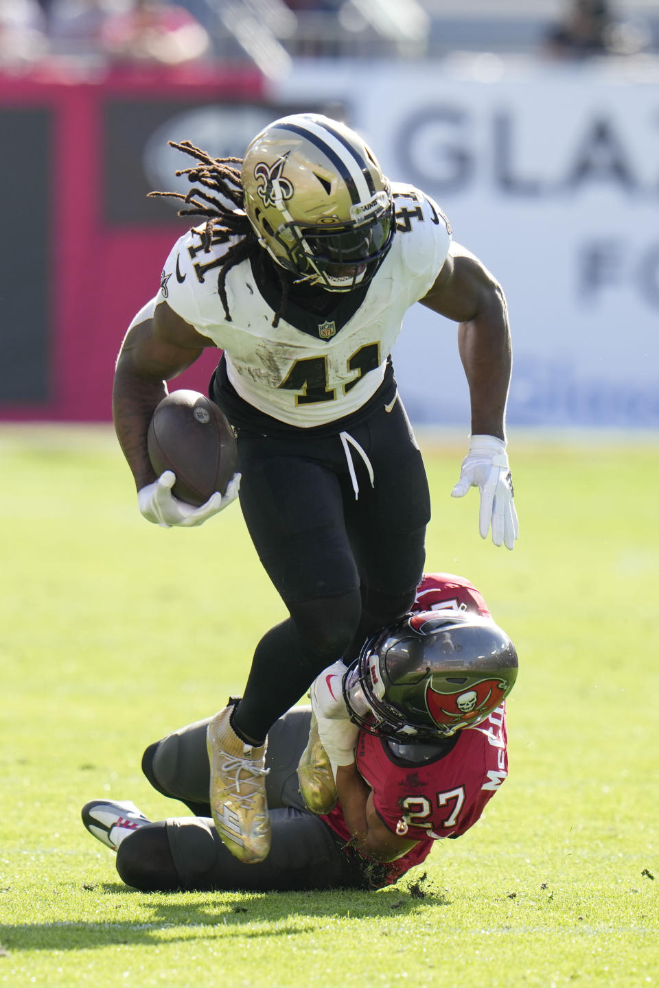 New Orleans Saints running back Alvin Kamara (41) is tackled by Tampa Bay Buccaneers cornerback Zyon McCollum (27) in the first half of an NFL football game in Tampa, Fla., Sunday, Dec. 31, 2023. (AP Photo/Chris O'Meara)