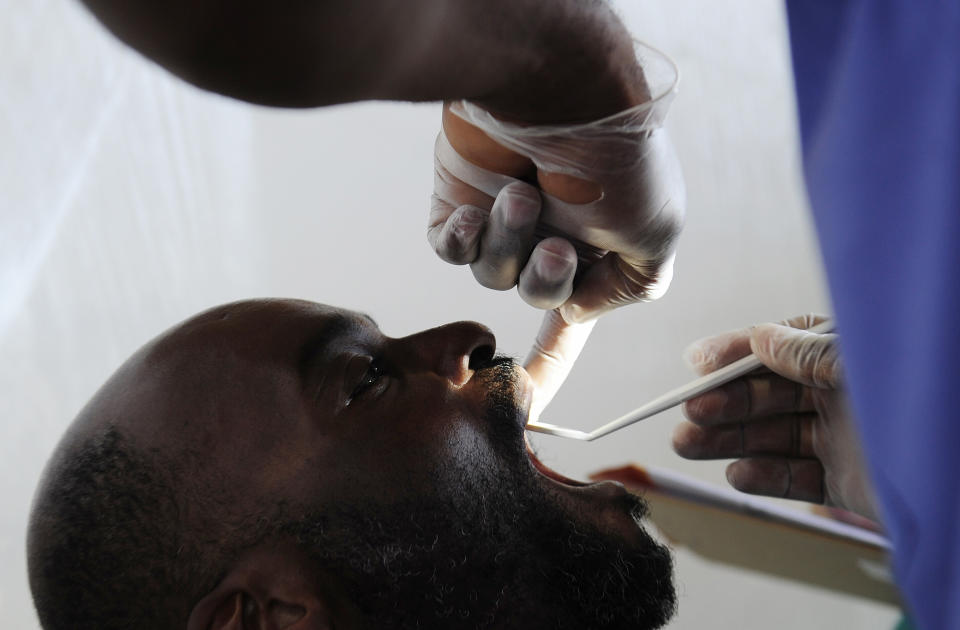 FILE - In this Friday, June 20, 2014, file photo, a patient's teeth are examined during a health screening hosted by Georgia Regents University at Costa Layman Nurseries in Trenton, S.C. Worrying what to do with your flexible spending account balance so you don't lose your money? Non-cosmetic dental procedures are covered: X-rays, fillings, crowns, braces, extractions, dentures and cleaning supplies, teeth cleaning and fluoride treatments to prevent tooth decay. (Sara Caldwell/The Augusta Chronicle via AP, File)