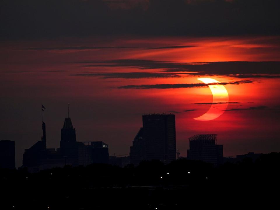 Eine partielle Sonnenfinsternis geht über der Skyline von Baltimore auf, Donnerstag, 10. Juni 2021, gesehen von Arbutus, Md. - Copyright: AP Photo/Julio Cortez