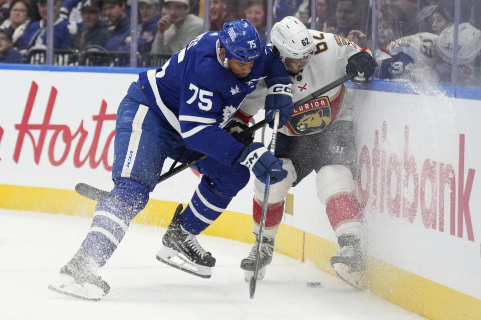 Toronto Maple Leafs right wing Ryan Reaves (75) and Florida Panthers defenseman Brandon Montour battle along the boards during the second period of an NHL hockey game in Toronto on Monday, April 1, 2024. (Frank Gunn/The Canadian Press via AP)