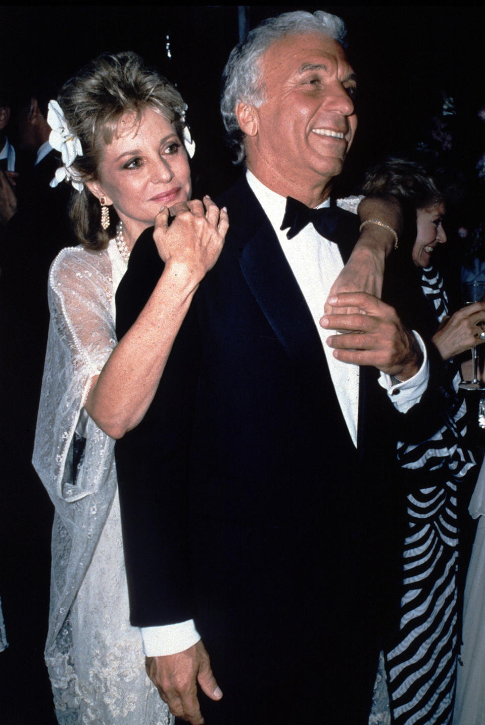 FILE - ABC television newscaster Barbara Walters wraps her arms around her husband, Merv Adelson, moments after their wedding ceremony on May 10, 1986, in Beverly Hills, Calif. Walters, a superstar and pioneer in TV news, has died, according to ABC News on Friday, Dec. 30, 2022. She was 93. (AP Photo/Peter Borsari, File)