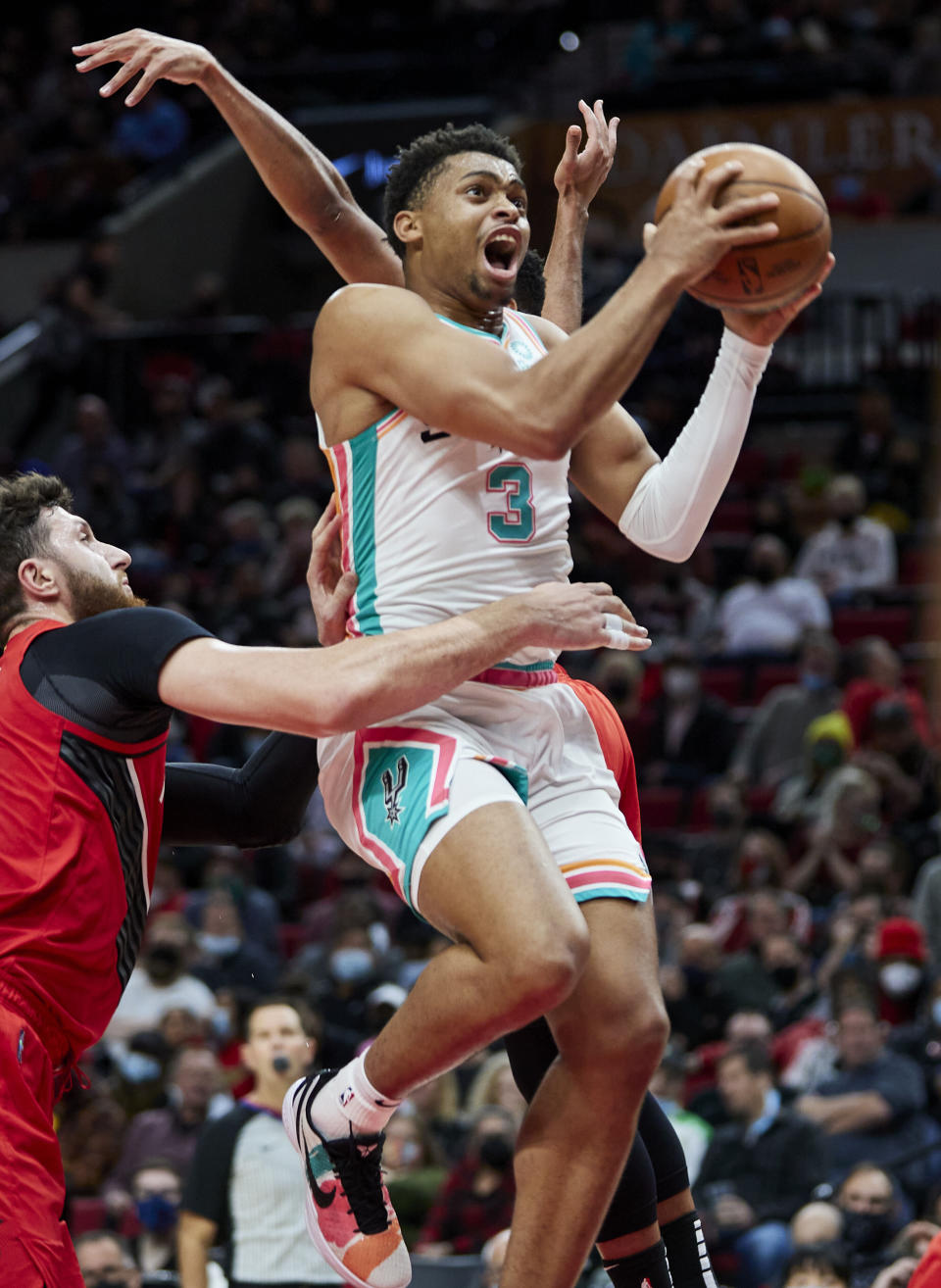 San Antonio Spurs forward Keldon Johnson, right, shoots over Portland Trail Blazers center Jusuf Nurkic during the first half of an NBA basketball game in Portland, Ore., Thursday, Dec. 2, 2021. (AP Photo/Craig Mitchelldyer)