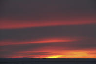 This photo, taken just after noon on Tuesday, Nov. 29, 2022, shows the sun just rising above the horizon in Nuiqsut, Alaska. Operation Santa Claus, the Alaska National Guard's outreach program, attempts to bring Santa and Mrs. Claus and gifts to children in two or three Alaska Native villages each year, including Nuiqsut in 2022. (AP Photo/Mark Thiessen)