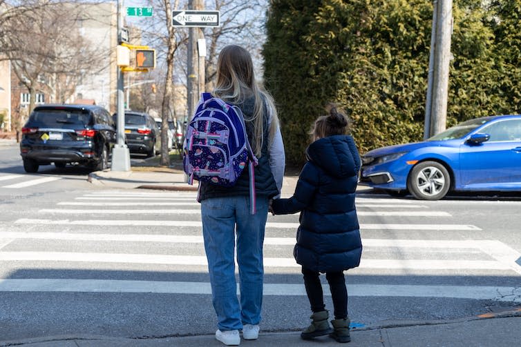 Woman walking home from school with child