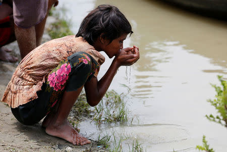 A Rohingya refugee girl drinks river water as she waits for boat to cross the border through Naf river in Maungdaw, Myanmar, September 7, 2017.REUTERS/Mohammad Ponir Hossain