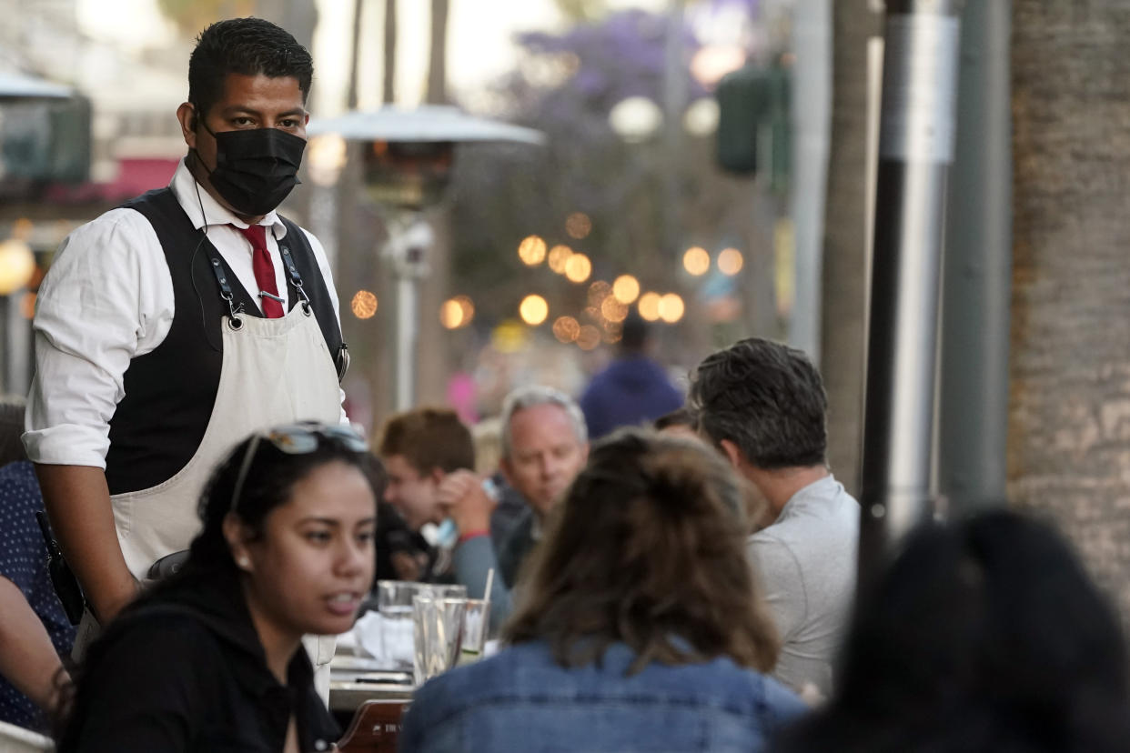 A server tends to customers in an outdoor dining area amid the COVID-19 pandemic on The Promenade Wednesday, June 9, 2021, in Santa Monica, Calif. (AP Photo/Marcio Jose Sanchez)