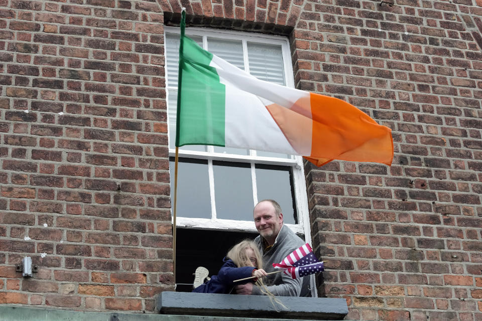 People look out of windows as they watch President Joe Biden who is on a walkabout in Dundalk, Ireland, Wednesday, April 12, 2023. (AP Photo/Patrick Semansky)