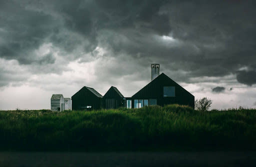 A home beneath a storm sky (Credit: Alexander Andrews via Unsplash)