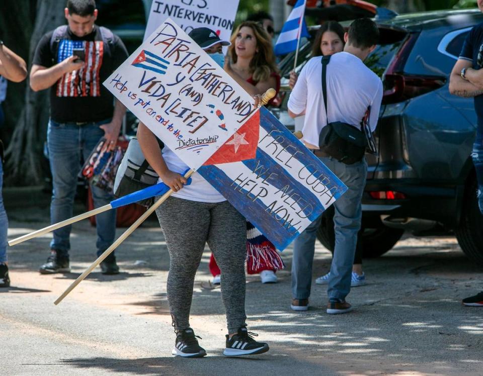 A woman carrying signs looks for friends as they wait to board buses bound for Washington, D.C.