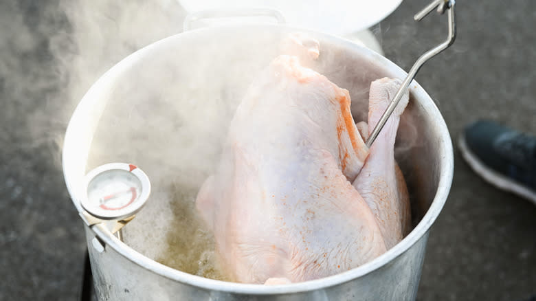 Raw turkey going into hot frying oil