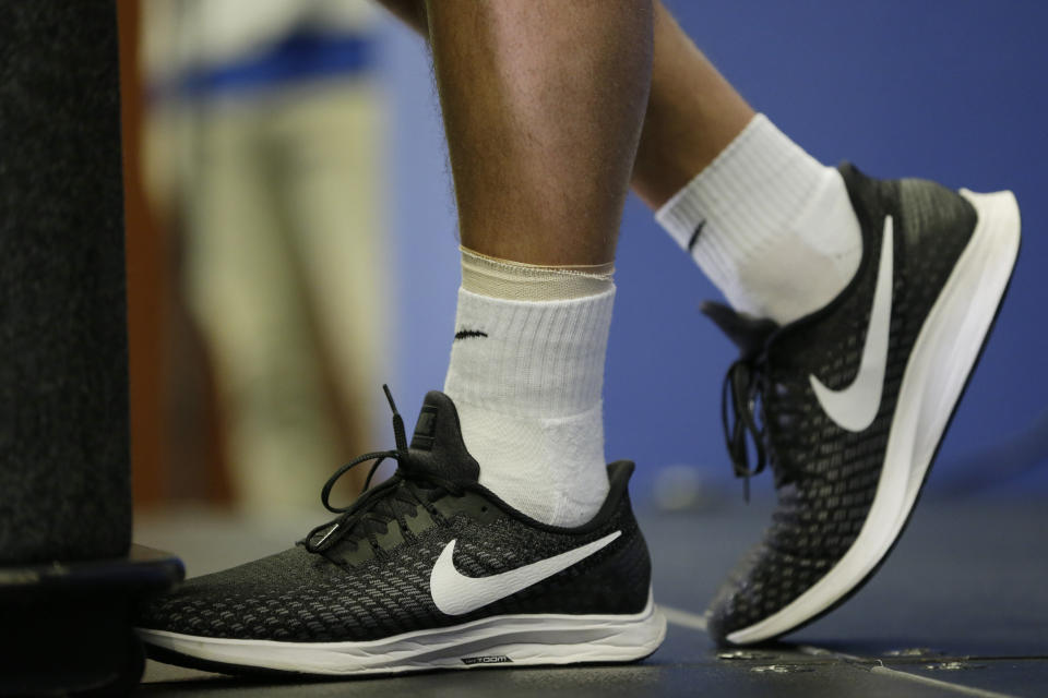 The injured ankle of Indianapolis Colts quarterback Andrew Luck is seen as he speaks during a news conference following the team's NFL preseason football game against the Chicago Bears, Saturday, Aug. 24, 2019, in Indianapolis. The oft-injured star is retiring at age 29. (AP Photo/AJ Mast)