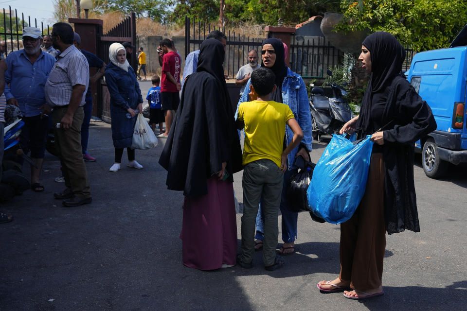 Palestinian residents carry their belongings as they flee their home after clashes that erupted between members of the Palestinian Fatah group and Islamist militants in the Palestinian refugee camp of Ein el-Hilweh near the southern port city of Sidon, Lebanon, Sunday, Sept. 10, 2023. Islamist factions in Lebanon's largest Palestinian refugee camp said Sunday they will abide by a cease-fire after three days of clashes killed at least five people and left hundreds of families displaced. (AP Photo/Bilal Hussein)