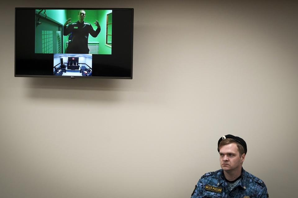 Russian opposition leader Alexei Navalny is seen on a TV screen as he appears in a video link provided by the Russian Federal Penitentiary Service in a courtroom of the Second Cassation Court of General Jurisdiction in Moscow, Russia, Tuesday, Oct. 18, 2022. Earlier this year, Navalny was sentenced to nine years in prison on the charges of fraud and contempt of court. This is his second appeal of the conviction, he lost the first one in May this year. (AP Photo/Alexander Zemlianichenko)