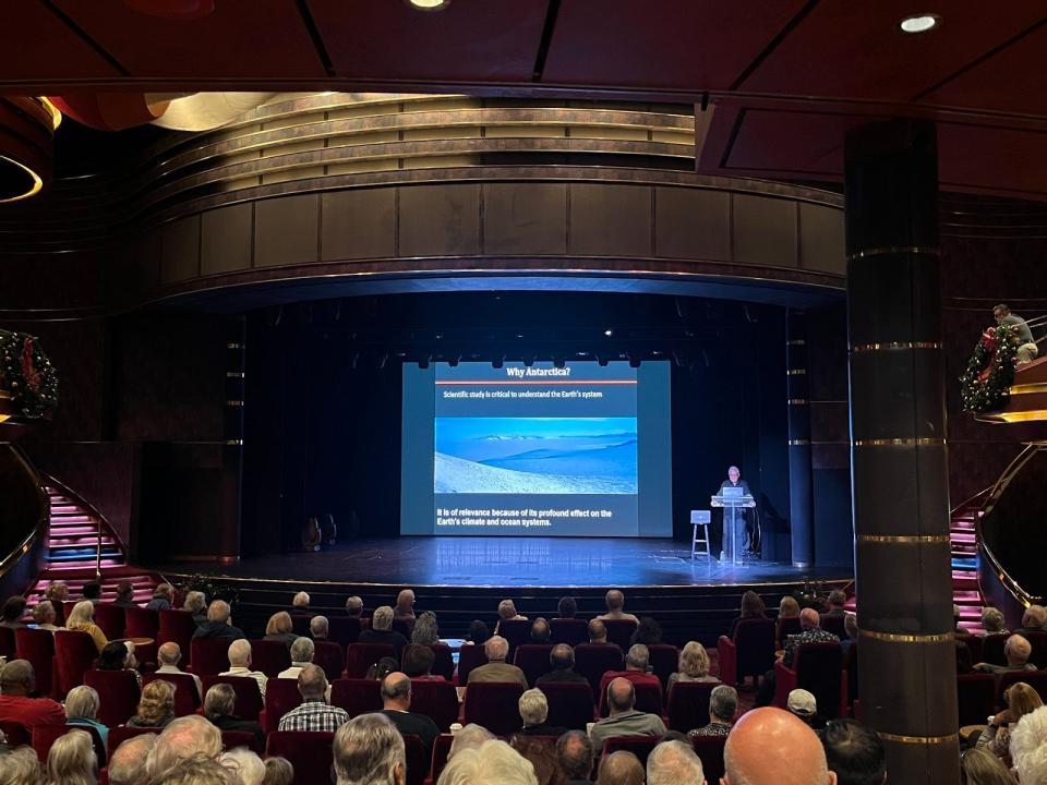 lecture space on a cruise ship filled with a crowd