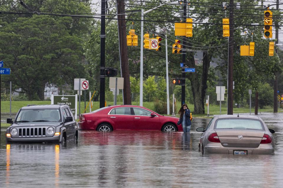 A woman walks back to her car after it was stranded in flood waters near the intersection of East Vine Street and East Crosstown Parkway in Kalamazoo, Mich., Thursday, June 20, 2019. (Photo: Joel Bissell/Kalamazoo Gazette via AP)