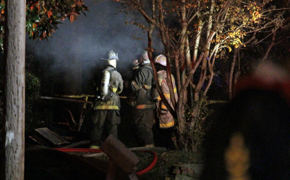 Fire fighters re-enter a west Jackson, Miss., home where authorities say a small plane carrying three people crashed shortly after 5 p.m. Tuesday evening, Nov. 13, 2012. The home's resident is believed to have escaped but authorities have not released names of plane's passengers. (AP Photo/Rogelio V. Solis)