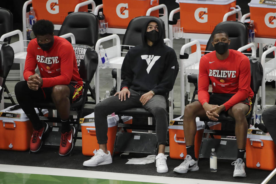 Atlanta Hawks' Trae Young, middle, looks up to the scoreboard from the bench during the second half of Game 5 of the team's NBA basketball Eastern Conference finals against the Milwaukee Bucks on Thursday, July 1, 2021, in Milwaukee. (AP Photo/Aaron Gash)