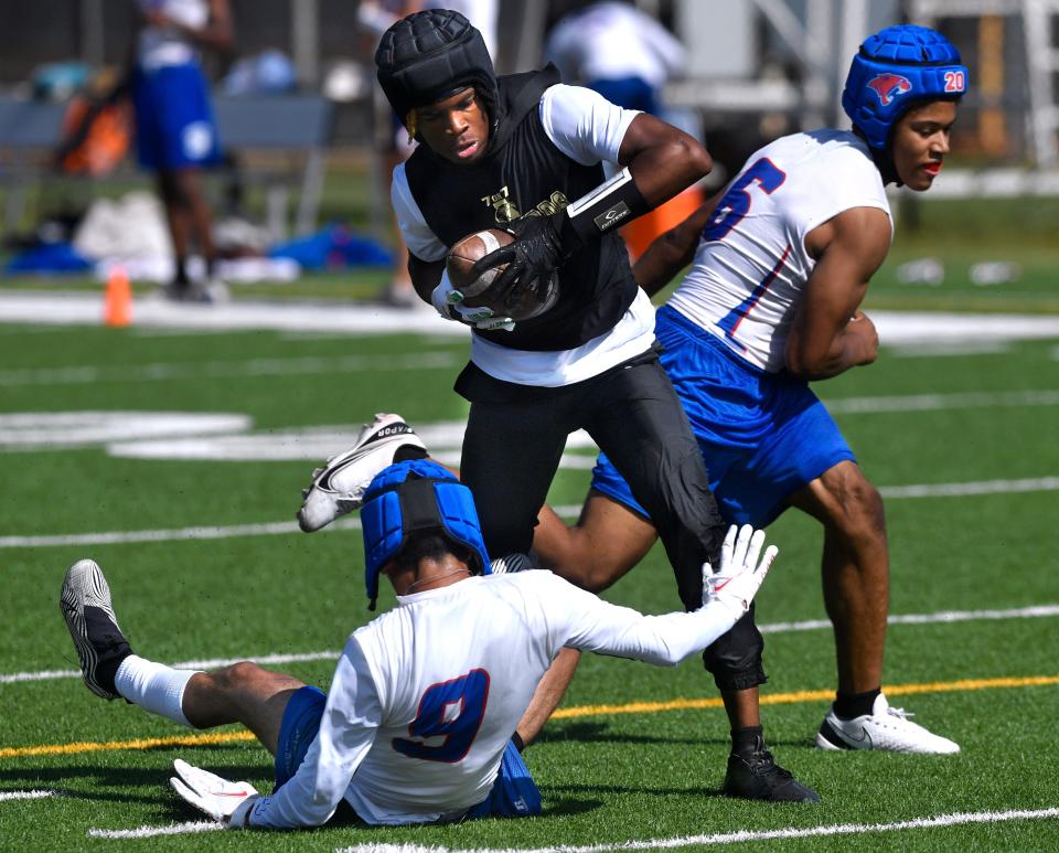 Abilene High's Jayson Henley catches a pass despite coverage from the Cooper High junior varsity team June 4.