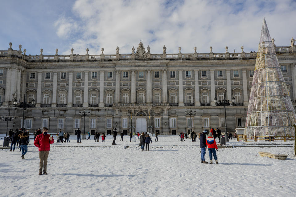 People walk through Oriente square covered with snow in downtown Madrid, Spain, Sunday, Jan. 10, 2021. A large part of central Spain including the capital of Madrid are slowly clearing snow after the country's worst snowstorm in recent memory. (AP Photo/Manu Fernandez)