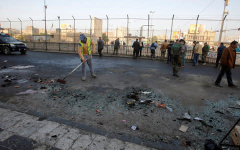 Iraqi security forces inspect the site of a bomb attack in Baghdad - Credit: KHALID AL-MOUSILY /REUTERS