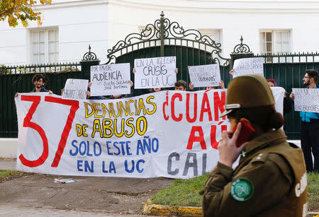 Demonstrators hold a banner that reads, "37 allegations of abuse this year at the Catholic University", in front of the apostolic nunciature where Special Vatican envoys archbishop Charles Scicluna and father Jordi Bertomeu are at, in Santiago, Chile June 13, 2018. REUTERS/Rodrigo Garrido