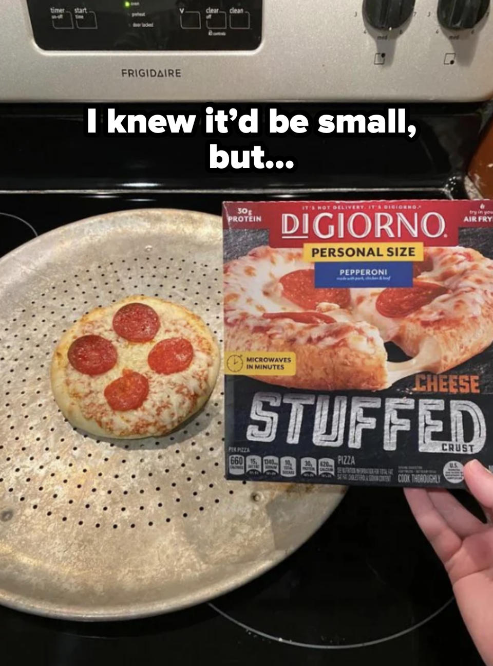 A hand holds a DiGiorno Personal Size Pepperoni Cheese Stuffed Crust Pizza box above a cooked pepperoni pizza placed on a perforated tray