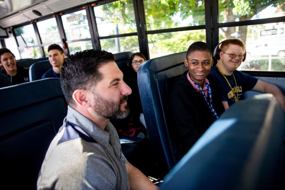 Naples High School teacher Mike Wexler, front, rides the bus with his students in Naples High School's Career Transition and Experience program on the way to a Christmas shopping trip at Big Lots at Park Shore Plaza in Naples on Friday, Nov. 22, 2019.