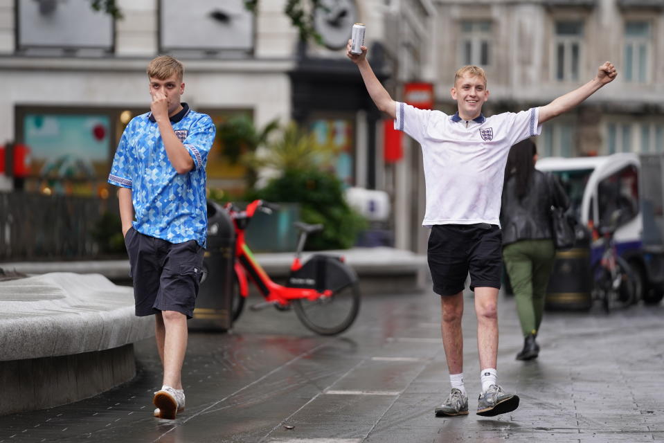 <p>Two England fans walk through London's Leicester Square the morning after their team were beaten in the final of the UEFA Euro 2020. Picture date: Monday July 12, 2021.</p>
