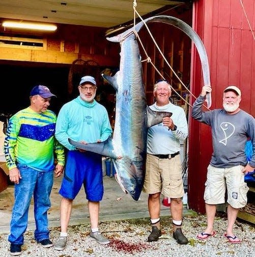 Dave Dube, Greg Vespe, Phil Duckett Jr. and Todd Corayer caught this 11-foot, 4-inch thresher shark when fishing southeast of Newport last summer.