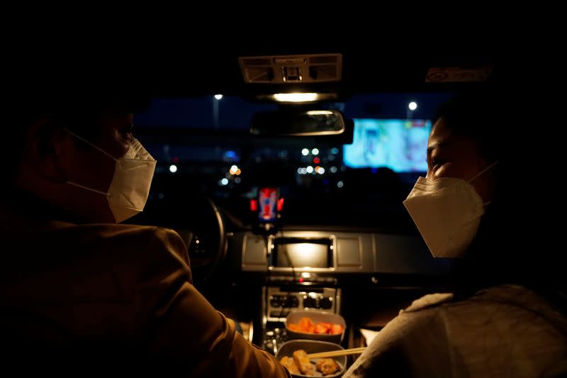 A couple prepares to watch a movie from their car at a drive-in theater that has been temporarily made for residents to enjoy movies while keeping social distancing following the outbreak of the coronavirus disease (COVID-19), in Seoul
