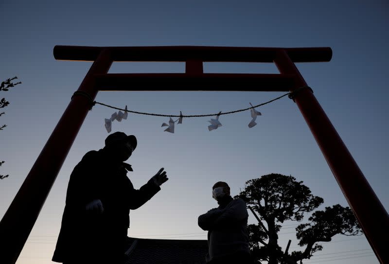 Residents of Hisanohama change Gohei on a torii gate in front of a memorial monument for the victims of the 2011 earthquake and tsunami at Akiba shrine ahead of the 10th anniversary of Fukushima disaster