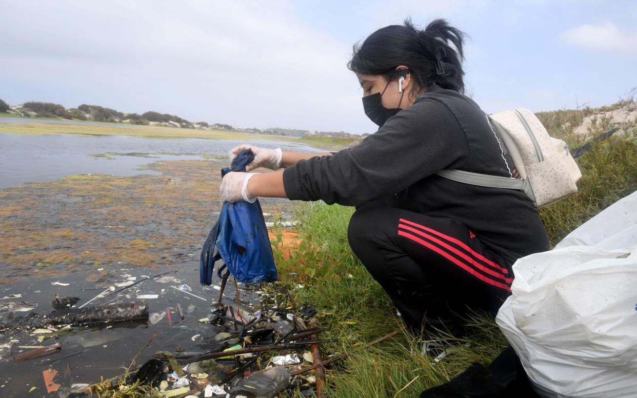 Genesis Salazar pulls trash from Ormond Lagoon during the 2022 Ventura County Coastal Cleanup Day. This year's event returns Sept. 23.