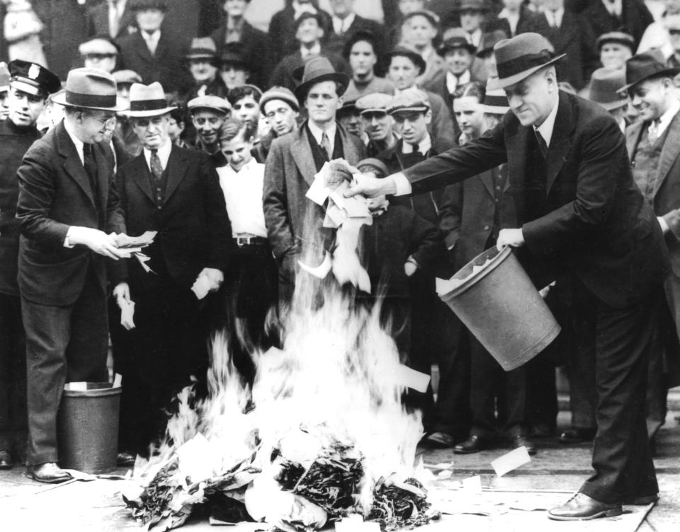 City council man, Mr. Barlow, and Treasury Secretary, Mr. Jil Martin, burning 100,000 dollars of "scrip money" (after the banks' closure),, April 1933,, United States,, National archives. Washington. (Photo by: Photo12/Universal Images Group via Getty Images)