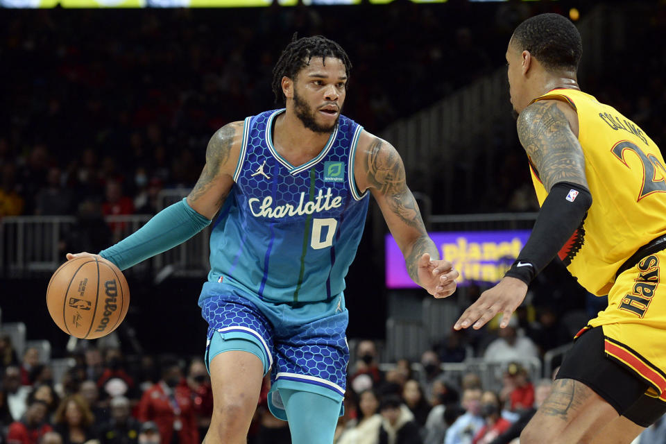 Charlotte Hornets forward Miles Bridges, left, drives around Atlanta Hawks forward John Collins during the second half of an NBA basketball game on Sunday, Dec. 5, 2021, in Atlanta. (AP Photo/Edward M. Pio Roda)