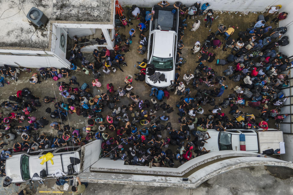 Migrants crowd into the patio at the Attorney Generals office after they were intercepted from inside cargo trailer trucks driving on the highway, in Coatzacoalcos, Veracruz state, Mexico, Friday, Nov. 19, 2021. About 500 migrants were riding in two cargo trucks when they were stopped and detained by the Criminal Investigation Agency and the National Immigration Institute, according to those two organiztions. (AP Photo/Felix Marquez)